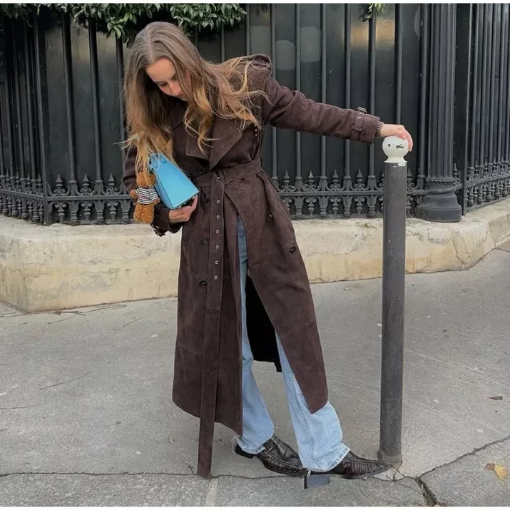 Model wearing a full-length suede trench coat in brown.
