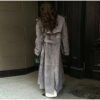 Model wearing a full-length suede trench coat in brown.