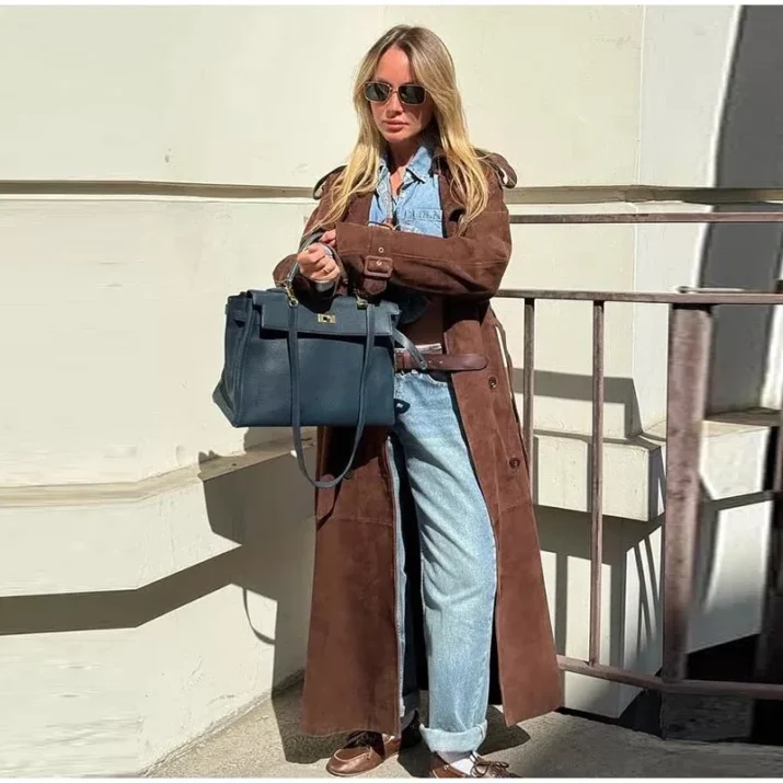 Model wearing a full-length suede trench coat in brown.