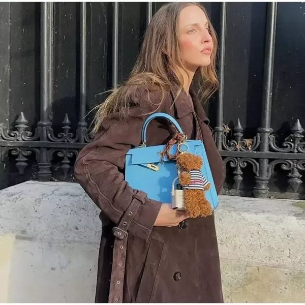 Model wearing a full-length suede trench coat in brown.