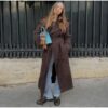 Model wearing a full-length suede trench coat in brown.
