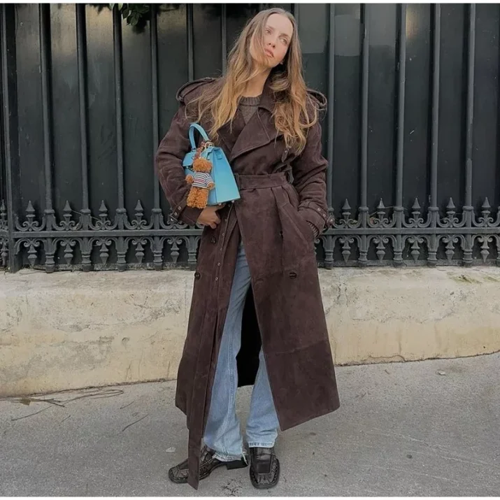 Model wearing a full-length suede trench coat in brown.