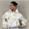 Model wearing an ivory cropped satin trench jacket with a black turtleneck.