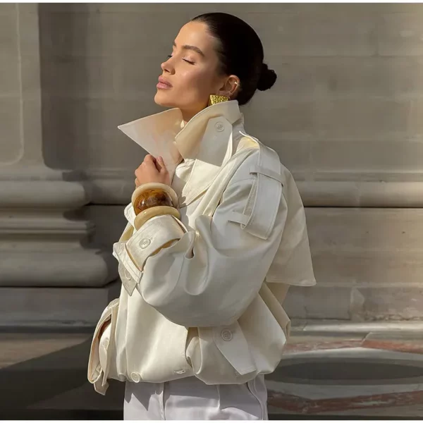 Model wearing an ivory cropped satin trench jacket with a black turtleneck.