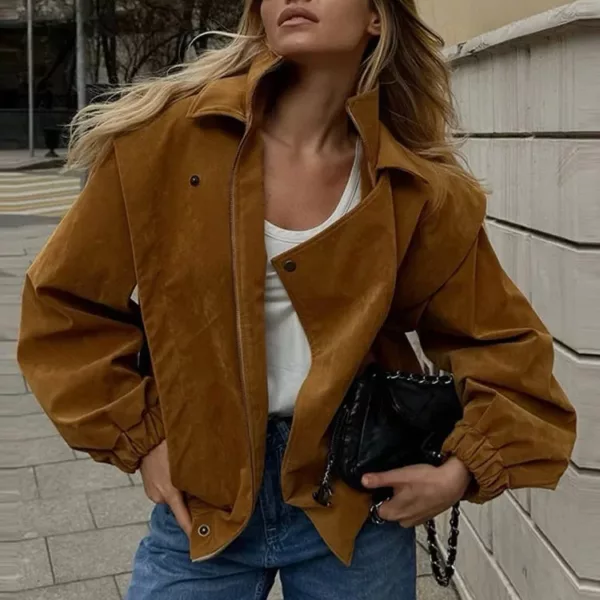 Model wearing a cropped suede bomber jacket with puff sleeves in a rich camel color