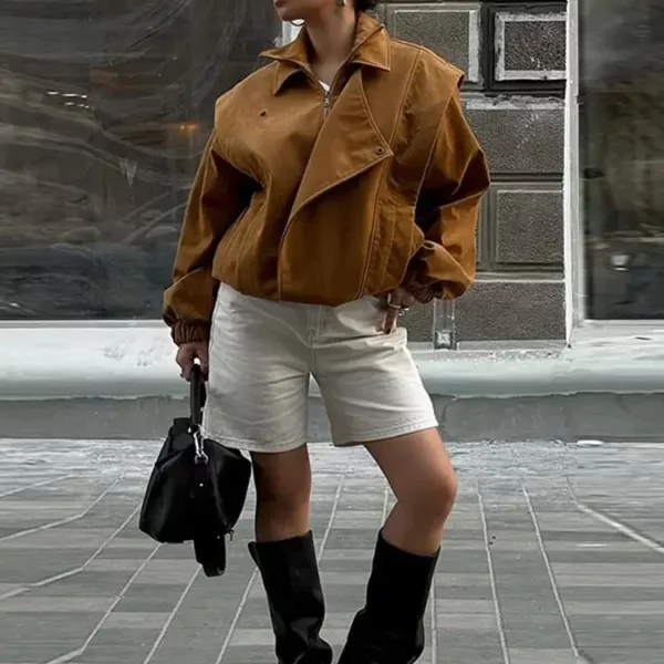 Model wearing a cropped suede bomber jacket with puff sleeves in a rich camel color