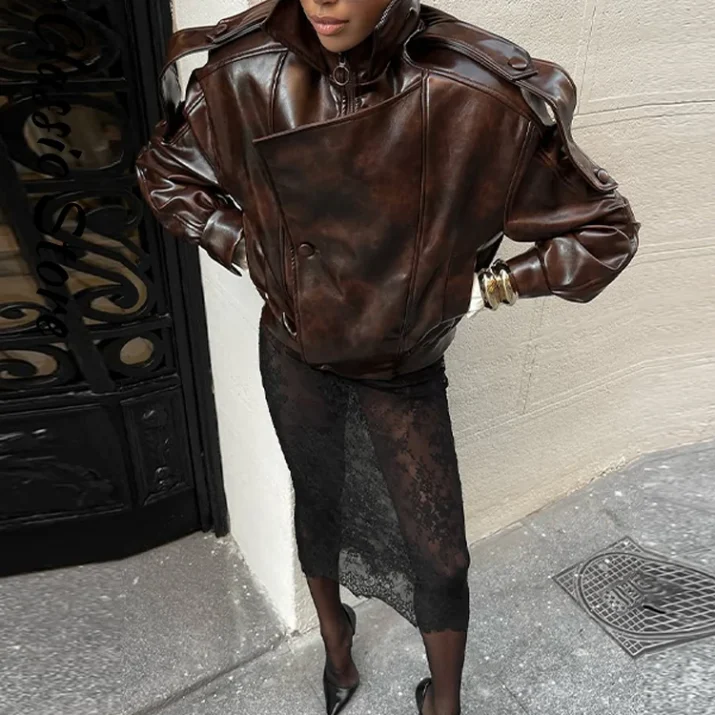 Close-up of dark brown leather jacket's high collar and buttoned front detail.